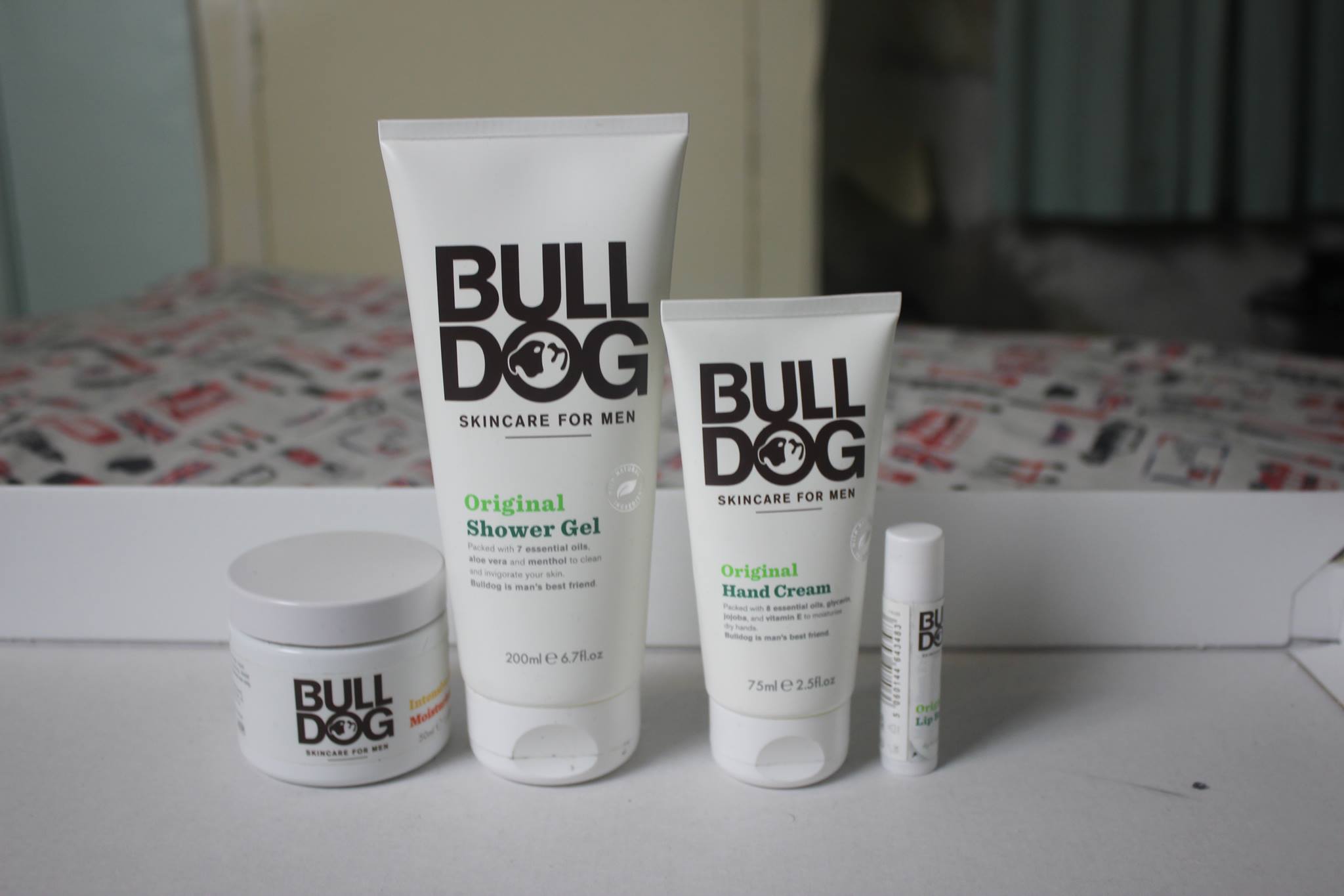 A picture of a cone shower gel bottle, a cone hand cream bottle, a small twist up lip balm tube, and a glass moisturiser tub.