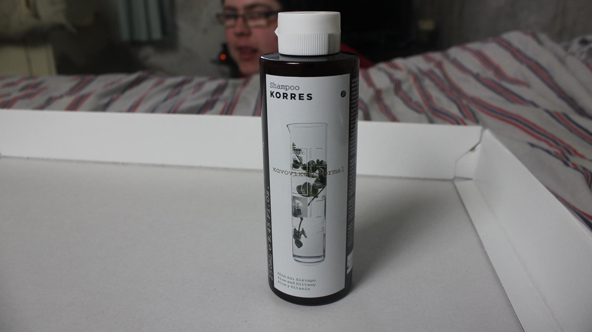 A tall tube shaped bottle of shampoo.