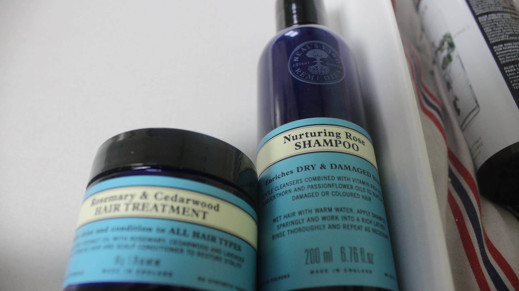 A tall, thin plastic shampoo bottle, and a small glass tub.