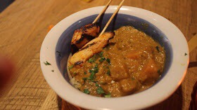A bowl of Curry and Rice with a Chicken Skewer.