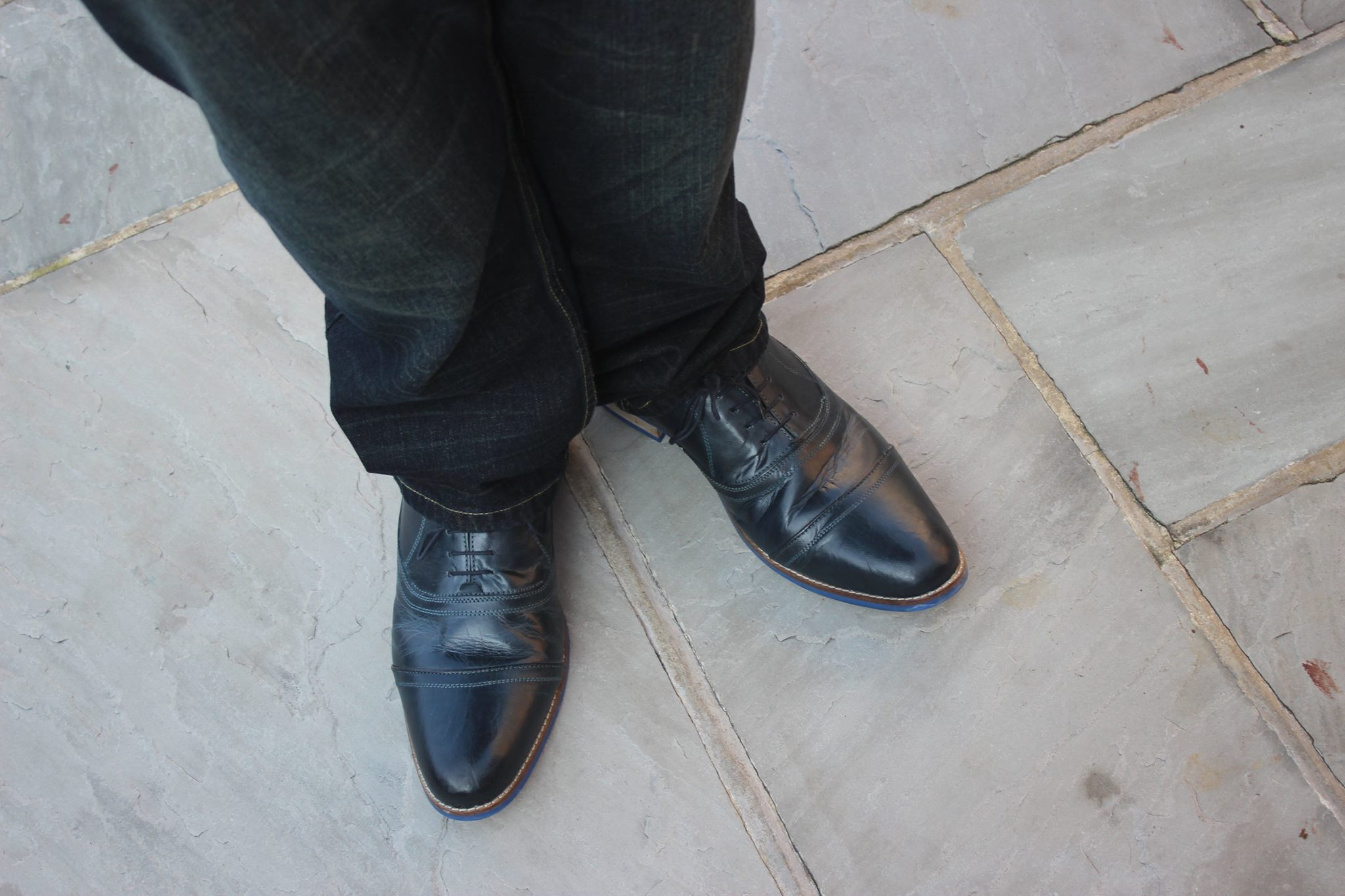 A person wearing a pair of Navy shoes.