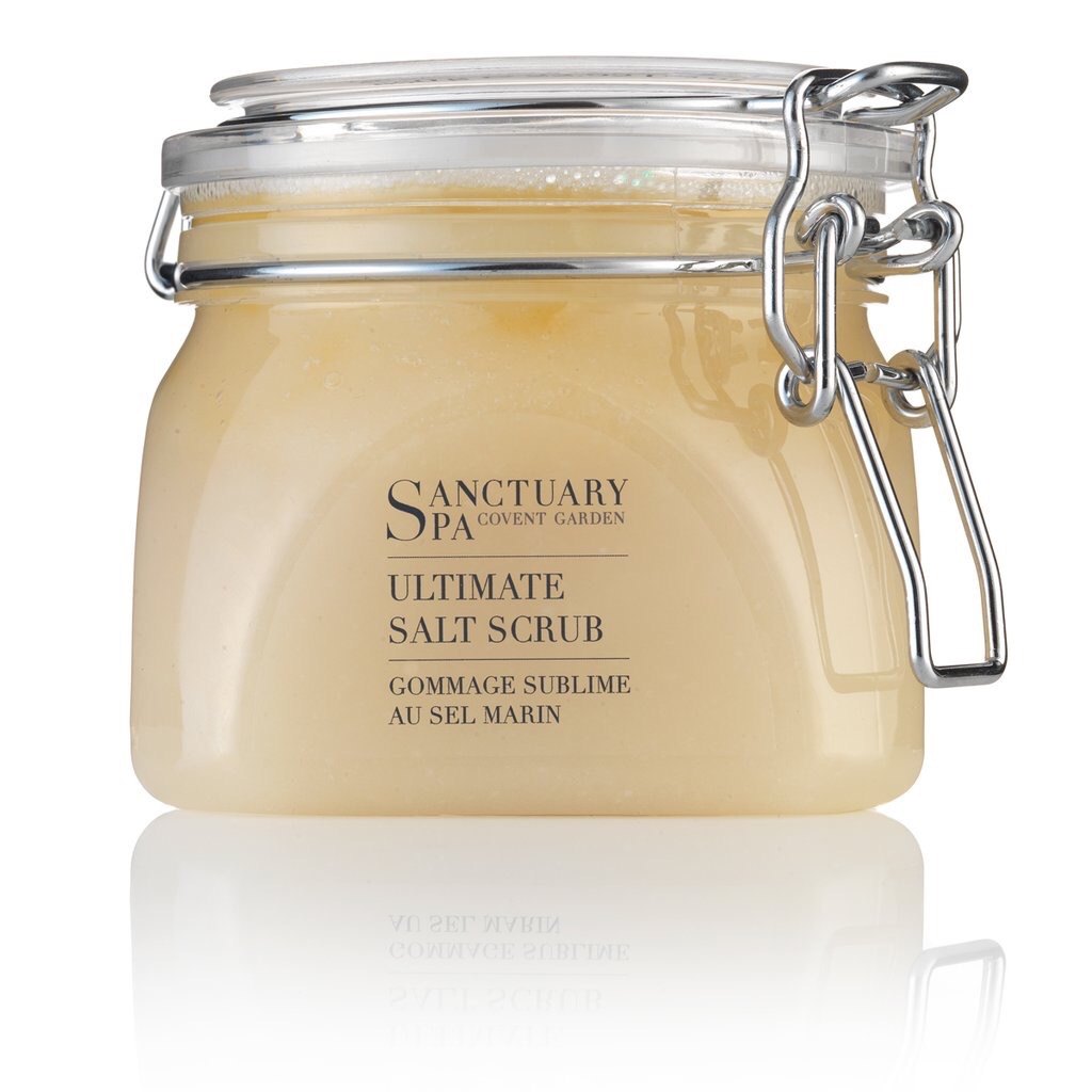 A big glass tub full of Salt scrub with metal clips on the side and labels saying Sanctuary Salt Scrub.