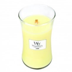 A large yellow wax candle in a glass jar.
